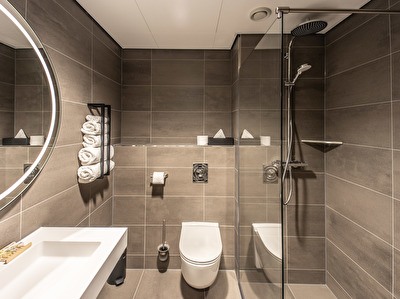 Luxurious bathroom of a Comfort room type with a rain shower and luminous mirror in Notiz Hotel Leeuwarden